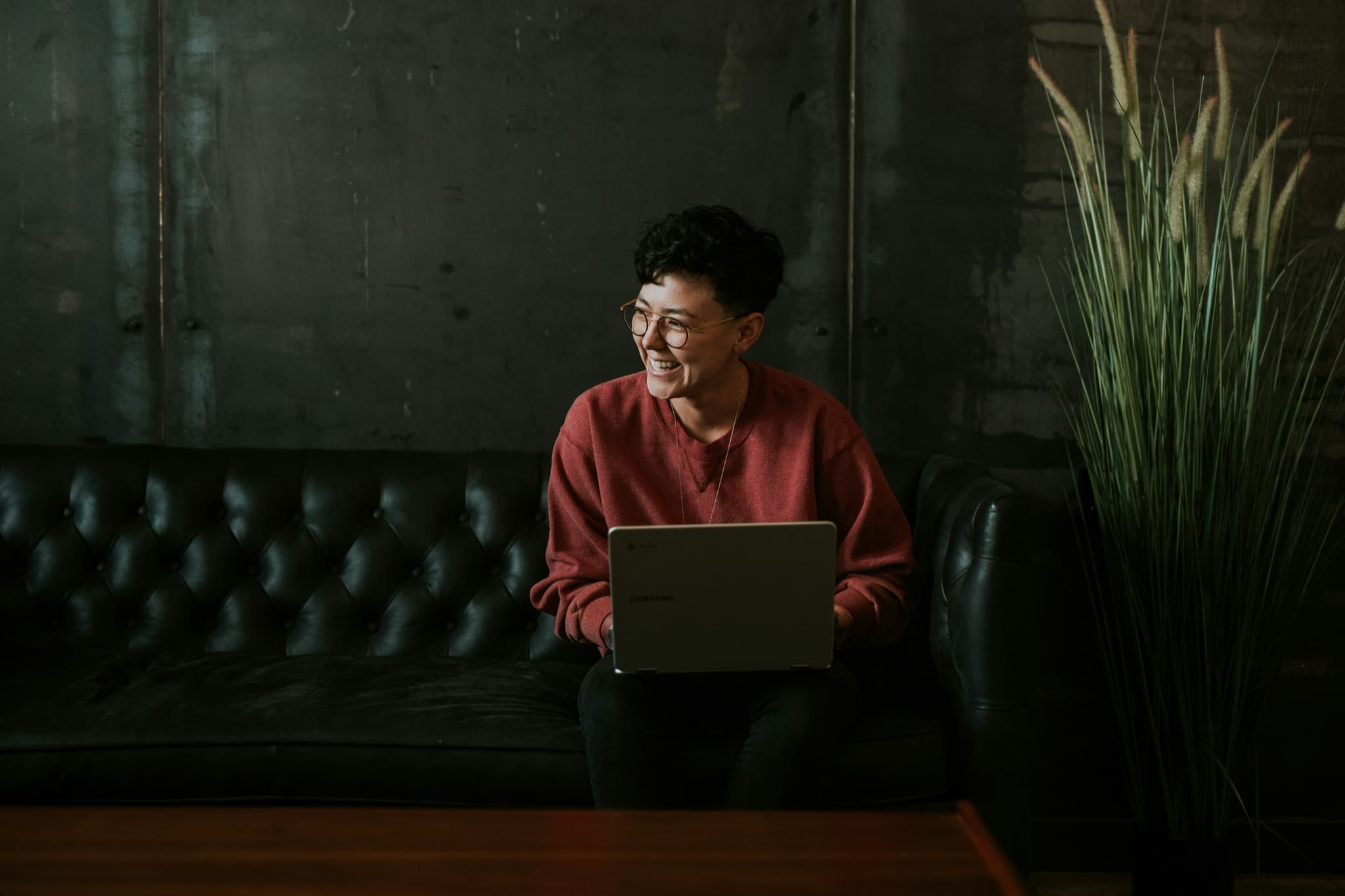 A smiling person working on a laptop