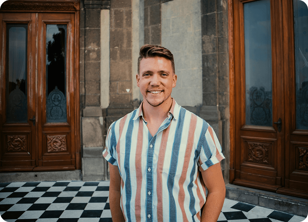 Person smiling in front of a historic building in Spain